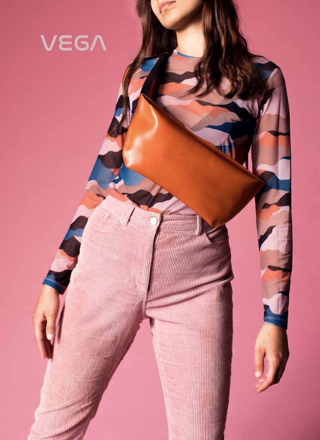 Ansicht eines weiblichen Fotomodells mit einer orangefarbenen Crossover-Bag